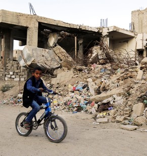 epa05641287 A young Yemeni on a bicycle rides past a house destroyed by a previous alleged Saudi-led airstrike, at a neighborhood in Sana&#039;a, Yemen, 21 November 2016. According to reports, the Sau ...