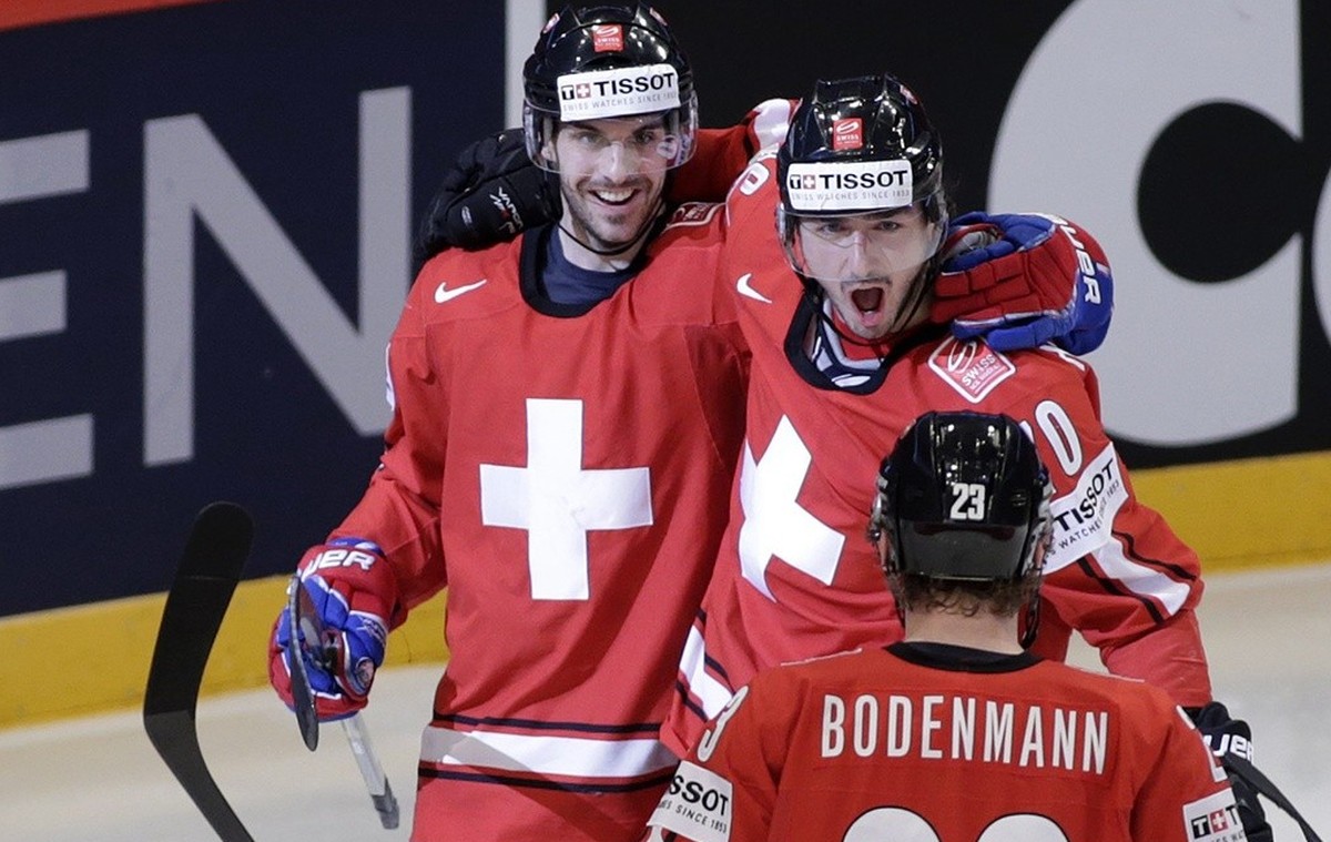 Switzerland's Luca Cunti, left, celebrates his goal with teammates Denis Hollenstein, centre, and Simon Bodenmann (23), after scored 1:0, during the IIHF Ice Hockey World Championships preliminar ...
