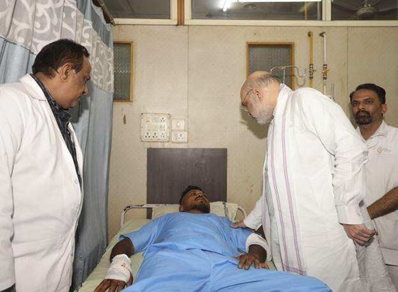 This handout photo issued by the Indian Ministry of Home Affairs shows Home Affairs Minister Amit Shah meeting British plane crash survivor Vishwash Kumar Ramesh, 40, at a hospital in Ahmedabad, after ...