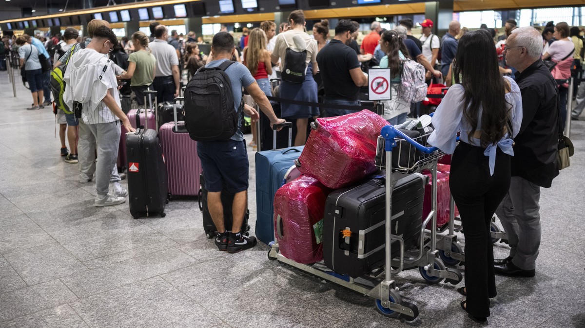epa10733745 People wait at the check-in counters before departing for their holidays at Zurich airport, Switzerland, 08 July 2023. EPA/ENNIO LEANZA