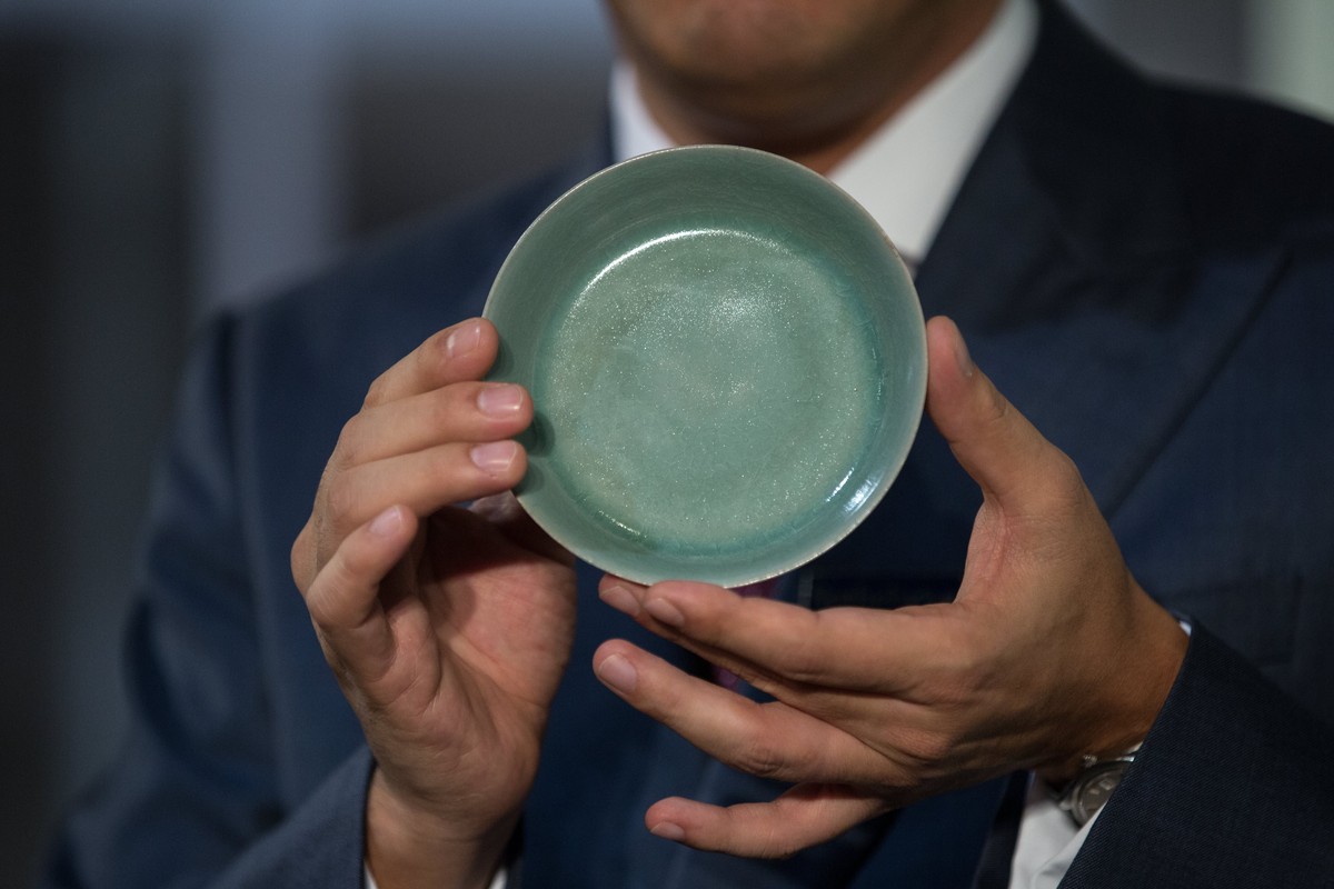 epa06240920 Nicolas Chow, Deputy Chairman, Sotheby's Asia International Head and Chairman, Chinese Works of Art, holds a Ru Guanyao Brush Washer from Northern Song Dynasty during the Chinese Work ...