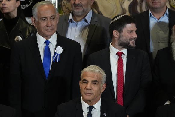 Israeli Prime Minister Yair Lapid, center, Likud Party leader Benjamin Netanyahu, left, far-right Israeli lawmaker Bezalel Smotrich and leaders of all Israel&#039;s political parties pose for a group  ...