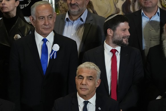Israeli Prime Minister Yair Lapid, center, Likud Party leader Benjamin Netanyahu, left-wing, far-right Israeli lawmaker Bezalel Smotrich and leaders of all Israeli political parties pose for a group photo...