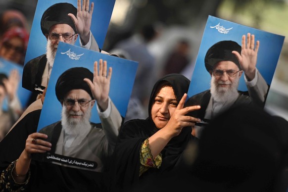 epaselect epa12727414 Supporters of the Tehreek-e-Bedari Ummat-e-Mustafa organization hold placards showing the Iranian Supreme leader Ali Khamenei during a solidarity rally with Iran, in Karachi, Pak ...