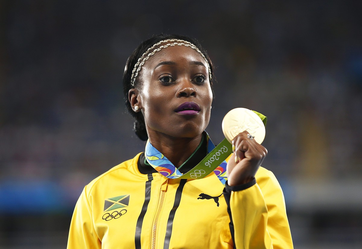 epa05497788 Elaine Thompson of Jamaica poses with her gold medal on the podium after winning the women's 200m final of the Rio 2016 Olympic Games Athletics, Track and Field events at the Olympic  ...
