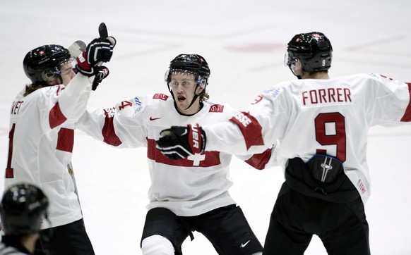 From left, Switzerland's Julien Privet, Dario Meyer and Marco Forrer celebrate the 2-0 goal by Meyer, during the 2016 World Junior Hockey Championships tournament match between Switzerland and Canada  ...