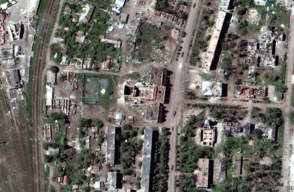 FILE - This satellite image provided by Maxar Technologies shows vehicles in a convoy amid extensive building damage throughout the town of Popasna, near Sievierodonetsk in the Luhansk region of Ukrai ...