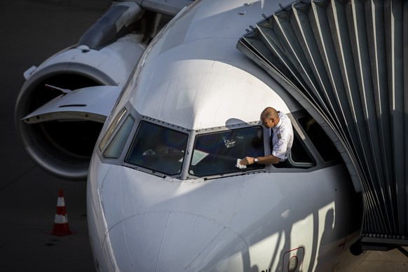 ARCHIV - KUENDIGUNG DES GAV UND ABRUCH DER VERHANDLUNGEN ZWISCHEN FLUGGESELLSCHAFT SWISS UND PILOTEN -- Ein Pilot der Swiss reinigt die Cockpit-Scheibe seines Airbus A319 am Flughafen Zuerich am Diens ...