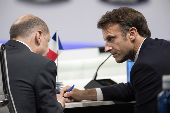 French President Emmanuel Macron speaks with Germany's Chancellor Olaf Scholz at the start of the second plenary session of the NATO summit in Madrid, Wednesday, June 29, 2022. North Atlantic Treaty Organization heads of state will meet for a NATO summit in Madrid from Tuesday through Thursday. (Eliot Blondet, Pool via AP)