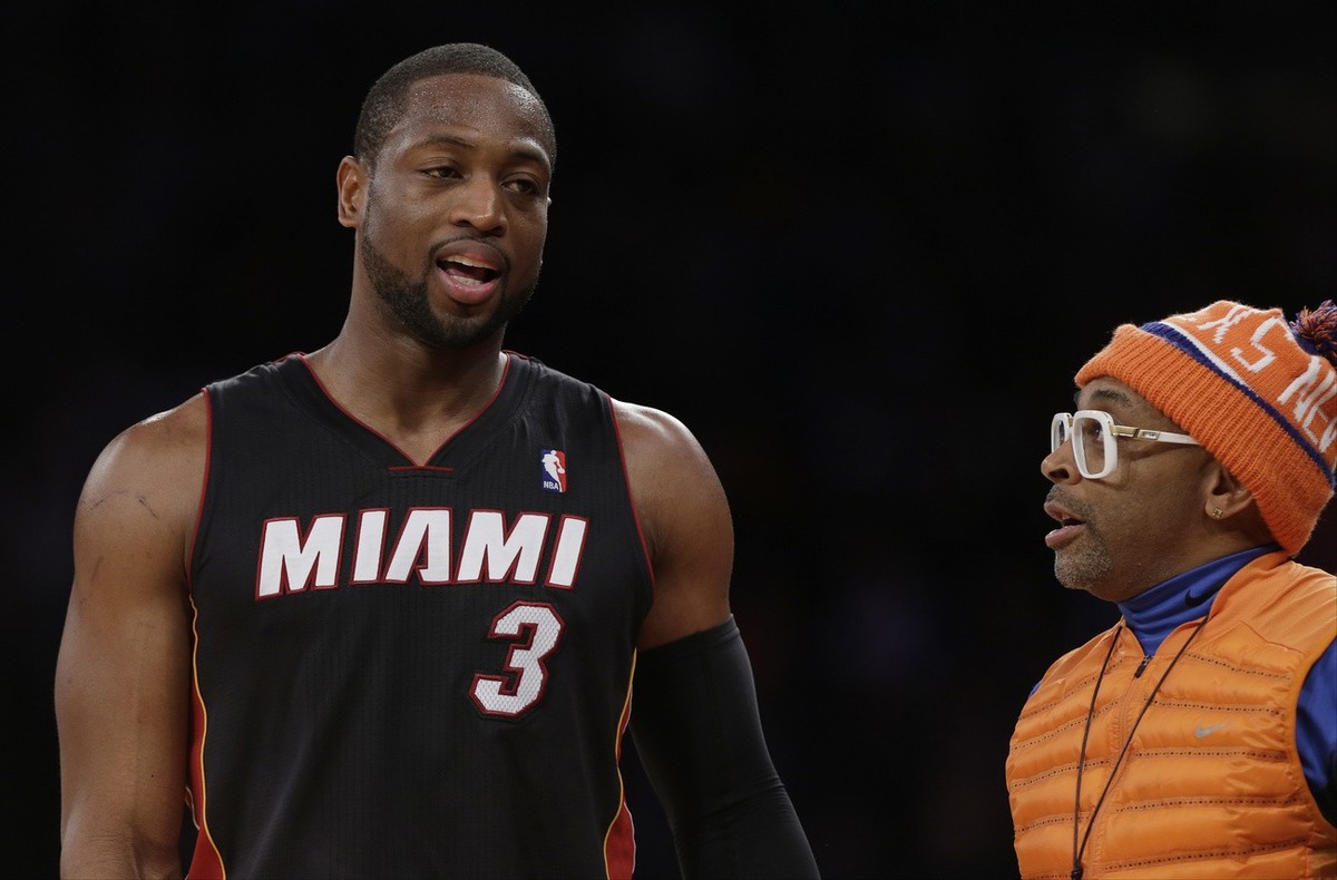 Miami Heat's Dwyane Wade, left, talks to Spike Lee during the second half of an NBA basketball game Thursday, Jan. 9, 2014, in New York. The Knicks won the game 102-92. (AP Photo/Frank Franklin I ...