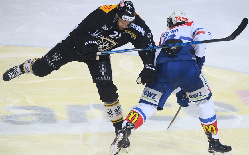 LuganoÕs player Jani Lajunen, left, fights for the puck with Zurich&#039;s player Fabrice Herzog, right, during the first match of the playoff final of National League between HC Lugano and ZSC lions, ...