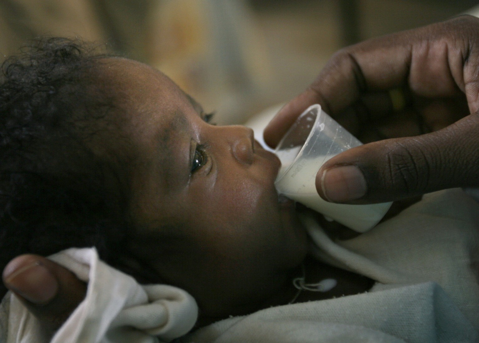 Myriam Ibrahim, a 28-year-old Sudanese mother of one month old triplets, Fawzia, Fardous and Fayrous feeds her daughter Fardous at El Fasher Therapeutic Feeding Center in the Darfur town of El Fasher, ...