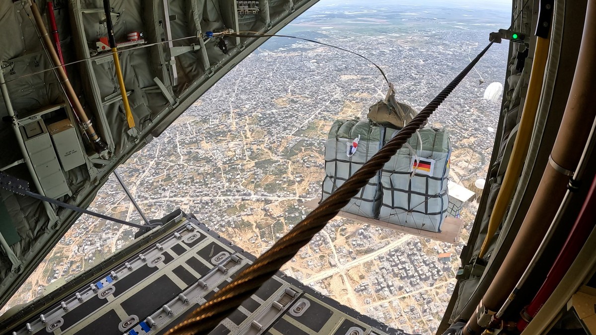 epa11224217 A handout photo made available by German Armed Forces shows a C-130 of the bi-national German-French squadron 'Rhein/Rhin' drops relief supplies over the Gaza Strip, 16 March 202 ...