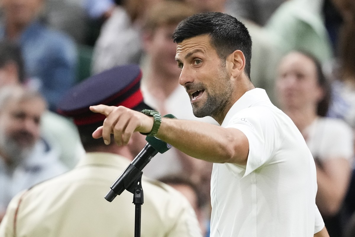 Novak Djokovic of Serbia gestures to the crowd as he is interviewed after defeating Holger Rune of Denmark in their fourth round match at the Wimbledon tennis championships in London, Monday, July 8,  ...