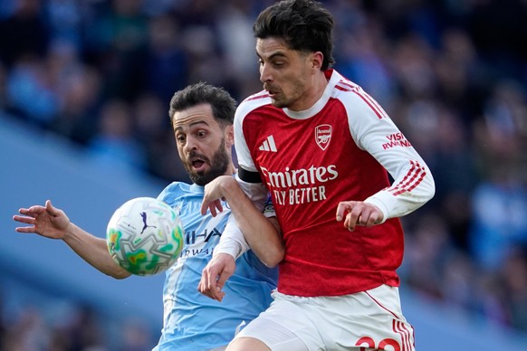Manchester City's Bernardo Silva, left, challenges for the ball with Arsenal's Kai Havertz during the English Premier League soccer match between Manchester City and and Arsenal, in Manchest ...