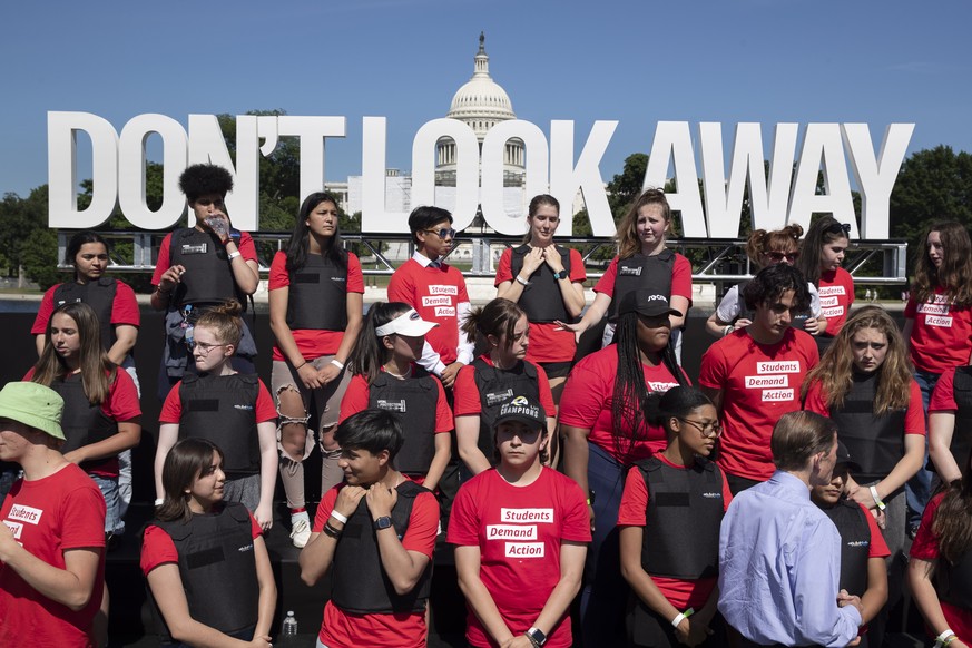 epa09999733 Children wear body armor during a rally held by gun safety supporters and advocates demanding gun safety reforms, on the west front of the US Capitol, in Washington, DC, USA, 06 June 2022. ...