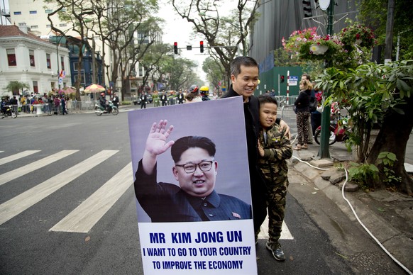 A boy with the hair-cut of North Korean leader Kim Jong Un look alike stands with a portrait of him outside Melia Hotel where Kim is staying in Hanoi, Vietnam, Wednesday, Feb. 27, 2019. Kim remained i ...