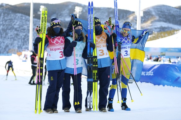 From left, Linn Persson, Mona Brorsson, Hanna Oeberg and Elvira Oeberg of Sweden pose after their first place finish in the women&#039;s 4x6-kilometer relay at the 2022 Winter Olympics, Wednesday, Feb ...