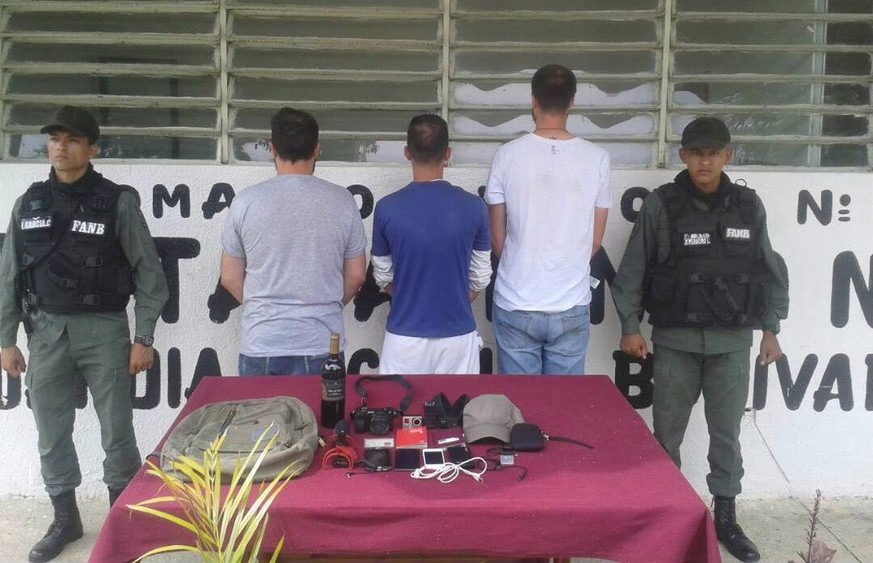 epa06252628 A handout photo made available by Eleazar Urbaez on 08 October 2017, shows two members of the Venezuela Bolivarian National Guard (GNB) while custody the journalists Jesus Medina, Roberto  ...