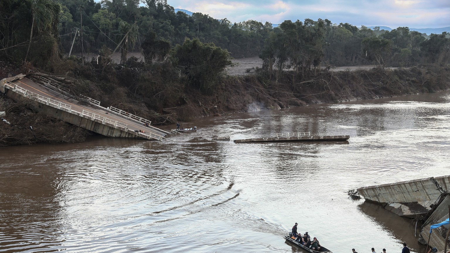epa11330268 Residents use a small boat to cross the Forqueta River after the collapse of the bridge that connected the cities of Lajeado and Arroio do Meio, Brazil, 09 May 2024. At least 108 people di ...