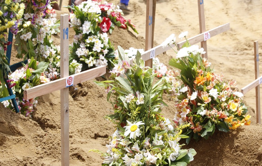 epa07522546 Coffins of the victims of a series of bomb blasts are buried at cemetery Don David Katuwapitiya during the mass funeral in Colombo, Sri Lanka, 23 April 2019. According to police, at least  ...