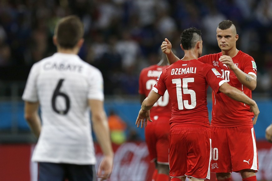 Switzerland&#039;s Blerim Dzemaili, center, celebrates with teammate Granit Xhaka after scoring the 5-1 during the group E preliminary round match between Switzerland and France in the Arena Fonte Nov ...