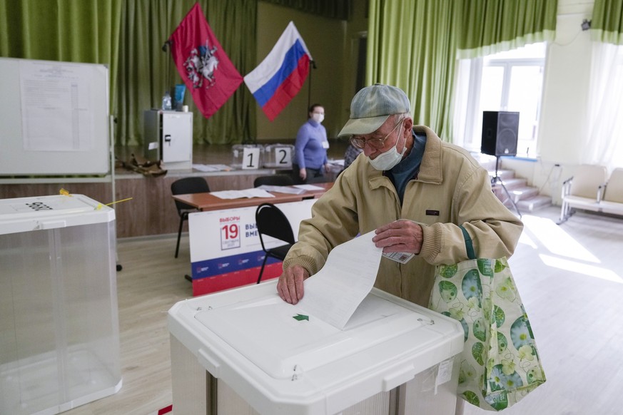 A man casts his ballot at a polling station during a parliamentary elections in Moscow, Russia, Saturday, Sept. 18, 2021. Sunday will be the last of three days voting for a new parliament that is unli ...