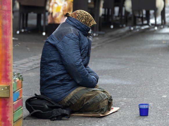 Eine Bettlerin sitzt auf dem Boden in der Steinentorstrasse in Basel, am Freitag, 20. November 2020. (KEYSTONE/Georgios Kefalas)