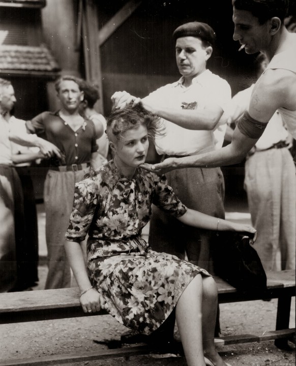 Einer französischen Prostituierten wird von Zivilisten der Kopf rasiert, um sie öffentlich zu brandmarken, 29. August 1944 in Montelimar.