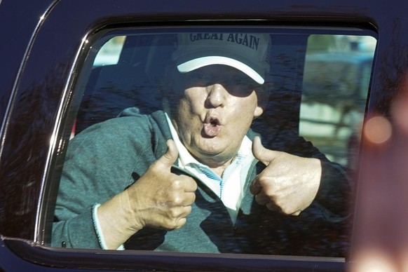 President Donald Trump gives two thumbs up to supporters as he departs after playing golf at the Trump National Golf Club in Sterling Va., Sunday Nov. 8, 2020. (AP Photo/Steve Helber)