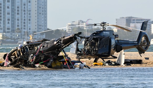 epa10386029 Two helicopters are seen following a collision near Seaworld, on the Gold Coast, Australia, 02 January 2023. Four people are dead and another 13 injured after two helicopters collided befo ...