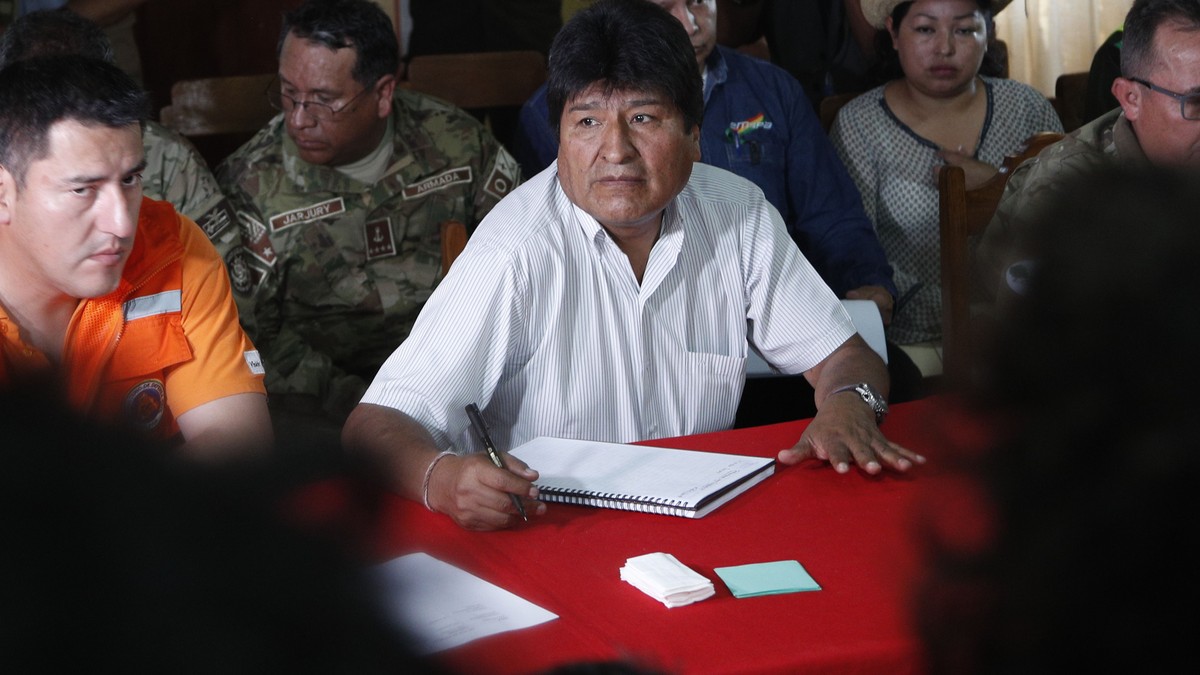 Bolivia's President Evo Morales, center, sits next to his Defense Minister Javier Zavaleta, left, during a meeting to discuss firefighting efforts in in Robore, Bolivia, Tuesday, Aug. 27, 2019. M ...