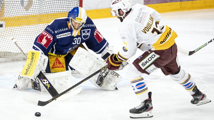 Zugs Torhueter Leonardo Genoni, links, im Spiel gegen Servettes Mathieu Vouillamoz, rechts, im ersten Eishockey Playoff-Finalspiel der National League zwischen dem EV Zug und Geneve-Servette HC am Mon ...