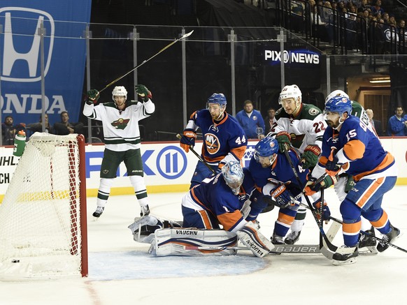 Minnesota Wild center Eric Staal (12) reacts as right wing Nino Niederreiter (22) shoots the puck past New York Islanders goalie Thomas Greiss (1), defenseman Calvin de Haan (44), defenseman Dennis Se ...