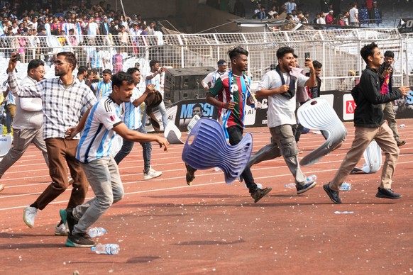 KEYPIX - Indian fans vandalize stadium chairs as they run on to the field after failing to get a glimpse of Argentine soccer star Lionel Messi at the Salt Lake Stadium, in Kolkata, India, Saturday, De ...