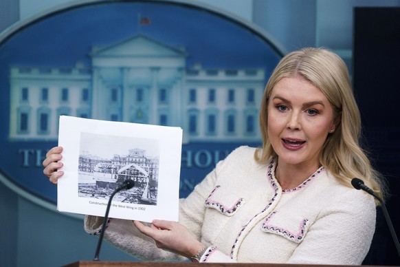 epa12476376 White House Press Secretary Karoline Leavitt holds images of previous White House renovations during a press briefing at the White House in Washington, DC, USA, 23 October 2025. EPA/WILL O ...