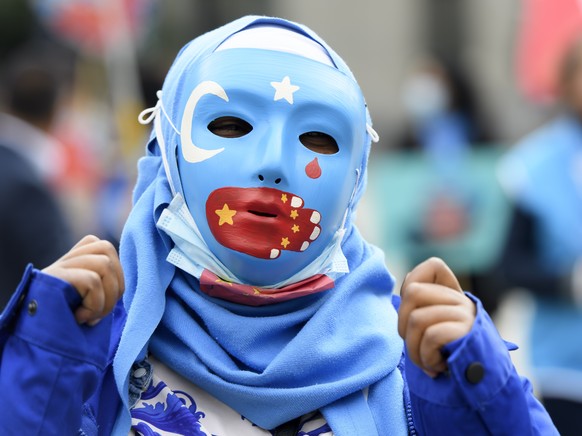 Personen mit Uiguren-Masken posieren auf dem Bundesplatz waehrend der Einreichung der Petition &quot;#NoComplicity: Schweiz muss Freihandelsabkommen mit China neu verhandeln!&quot;, am Montag, 7. Sept ...