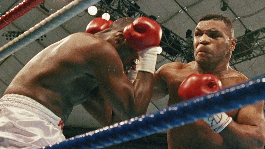 FILE - In this Feb. 11, 1990, file photo, World Heavyweight Champion Mike Tyson drives challenger James Douglas against the ropes during the first round in Tokyo. Wednesday, Feb. 11, 2015, marks the 2 ...