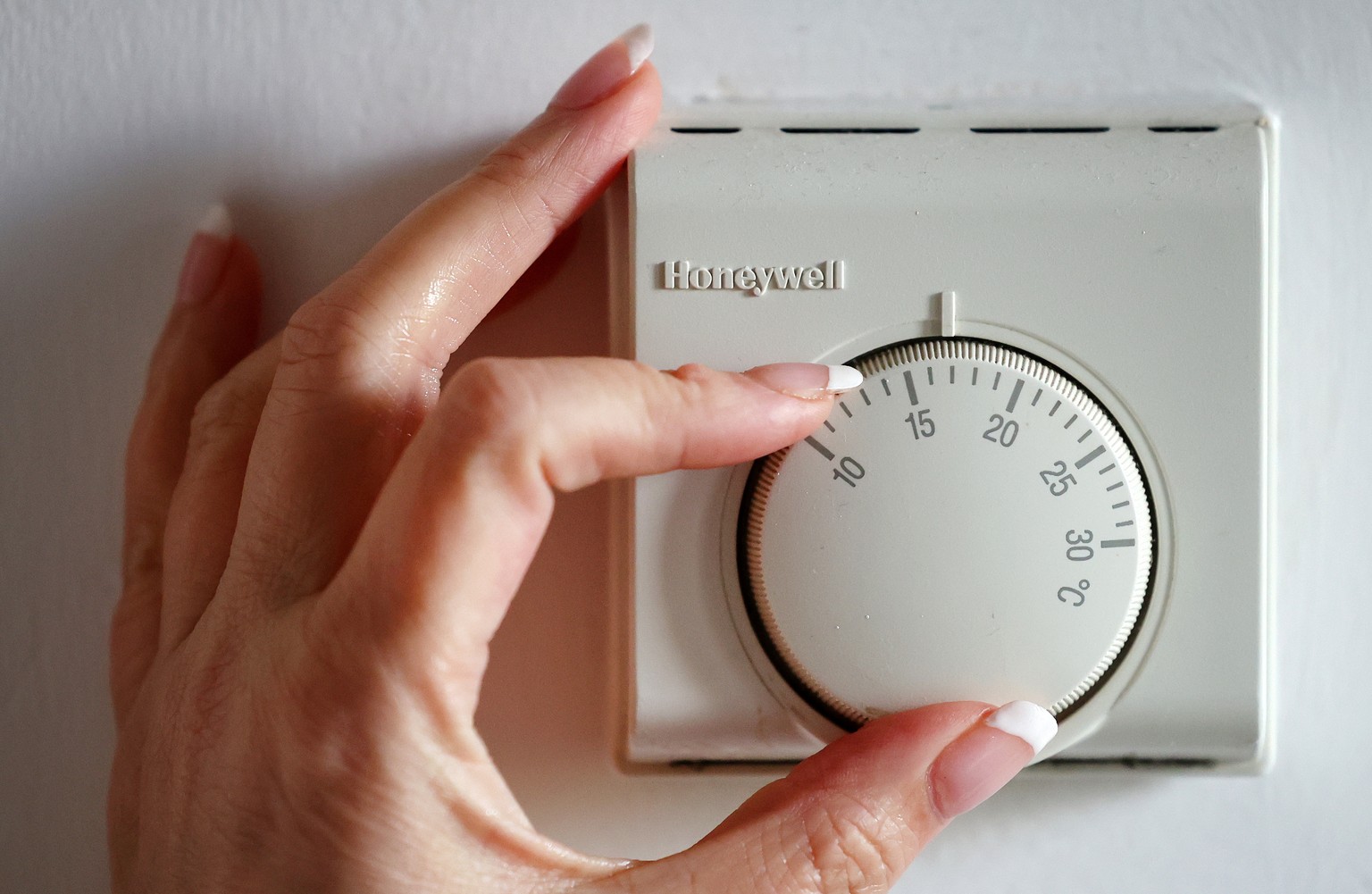 epa11254385 A person adjusts a thermostat at a home in London, Britain, 01 April 2024. UK energy prices have dropped to their lowest level for two years, following a price cap by energy regulator Ofge ...