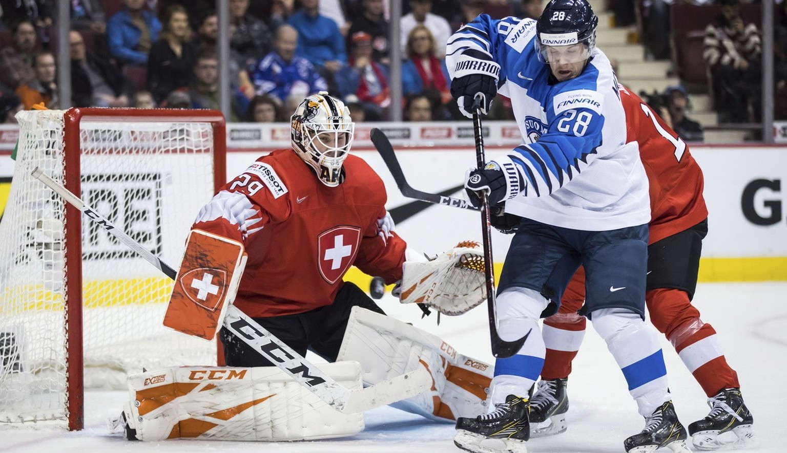 Finland&#039;s Sami Moilanen (28) tries to tip the puck in front of Switzerland goalie Akira Schmid (29) during third-period IIHF world junior semifinal hockey action in Vancouver, British Columbia, F ...