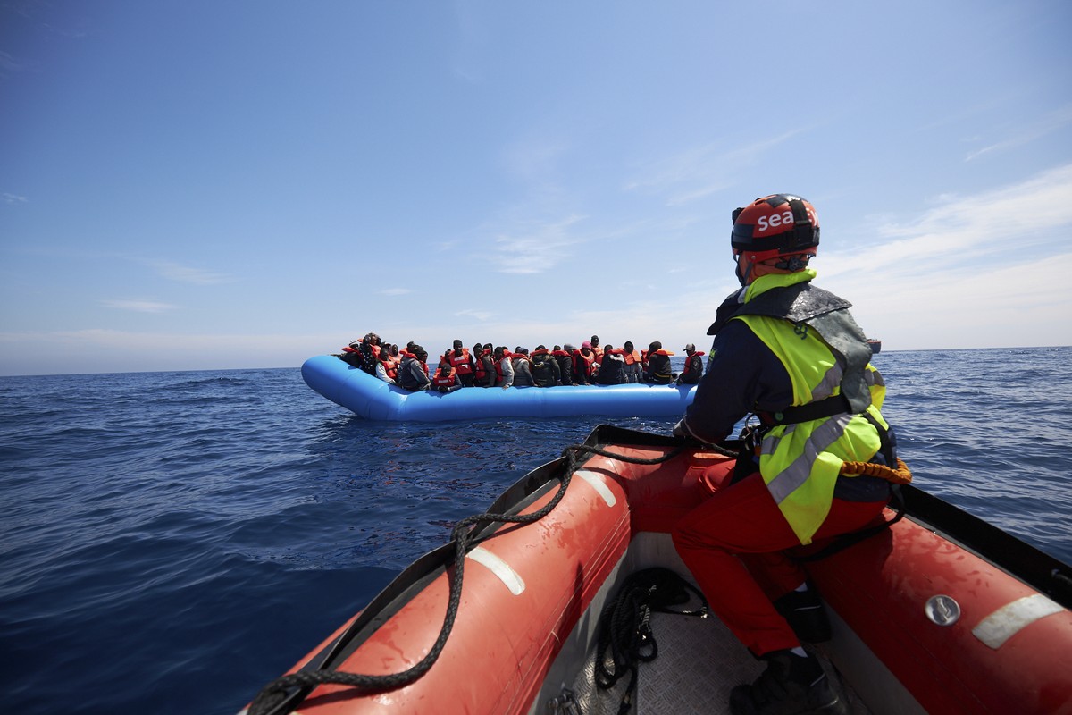 Migrants on a rubber dinghy are approached by Sea-Watch rescue ship's staffers in the waters off Libya Wednesday, April 3, 2019. The German humanitarian group Sea-Watch says the ship it operates  ...