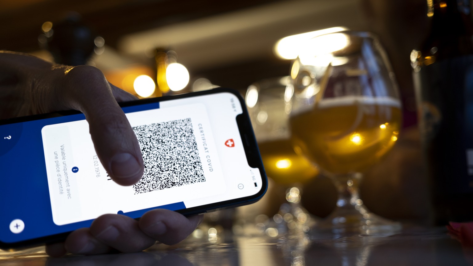 Une personne tient dans sa main un smartphone avec l&#039;application Certifact Covid suisse dans un restaurant ce vendredi 10 septembre 2021 a Rances dans le canton de Vaud. Des ce lundi 13 septembre ...
