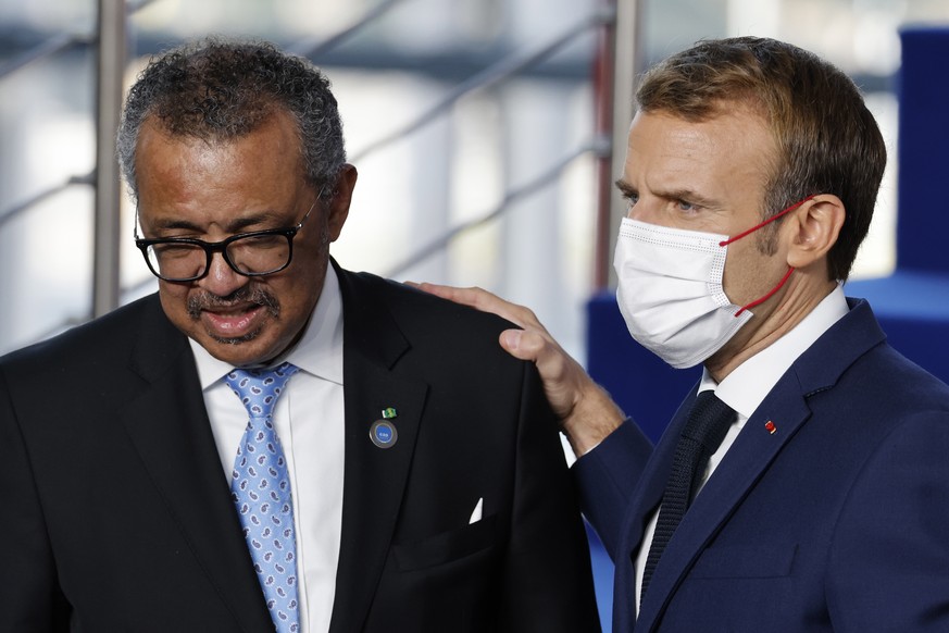 epa09553717 World Health Organization (WHO) Director-General Tedros Adhanom Ghebreyesus (L) listen to French President Emmanuel Macron at the start of the G20 Summit at the convention center La Nuvola ...