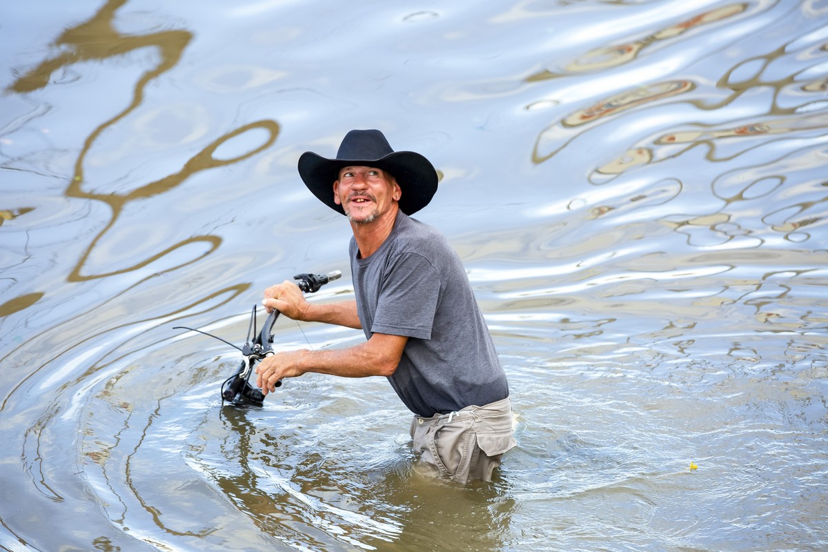 epa11467563 A man navigates flood waters following heavy rain from Hurricane Beryl in Houston, Texas, USA, 08 July 2024. The storm, which already caused widespread damage last week in the Caribbean, w ...