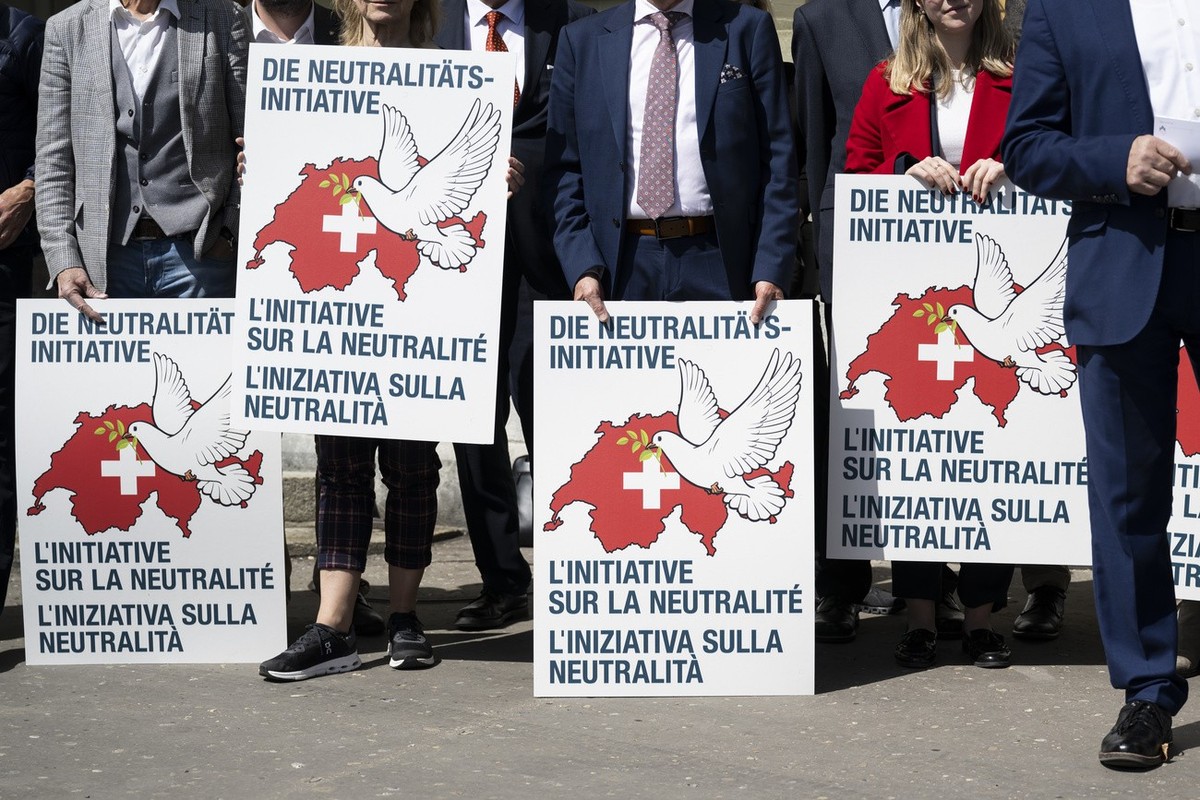 Unterstuetzer halten Plakate anlaesslich der Einreichung der eidgenoessischen Volksinitiative "Wahrung der schweizerischen Neutralitaet (Neutralitaetsinitiative)", am Donnerstag, 11. April 2 ...