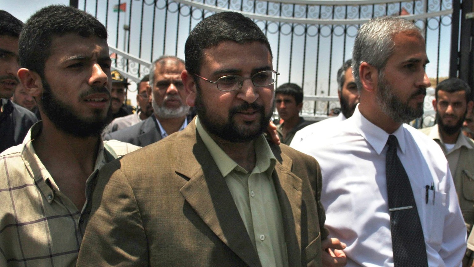 Hamas spokesman Sami Abu Zuhri, center, is escorted out of the terminal of the Rafah border crossing between Egypt and the Gaza Strip Friday, May 19, 2006. Palestinian security forces loyal to Preside ...