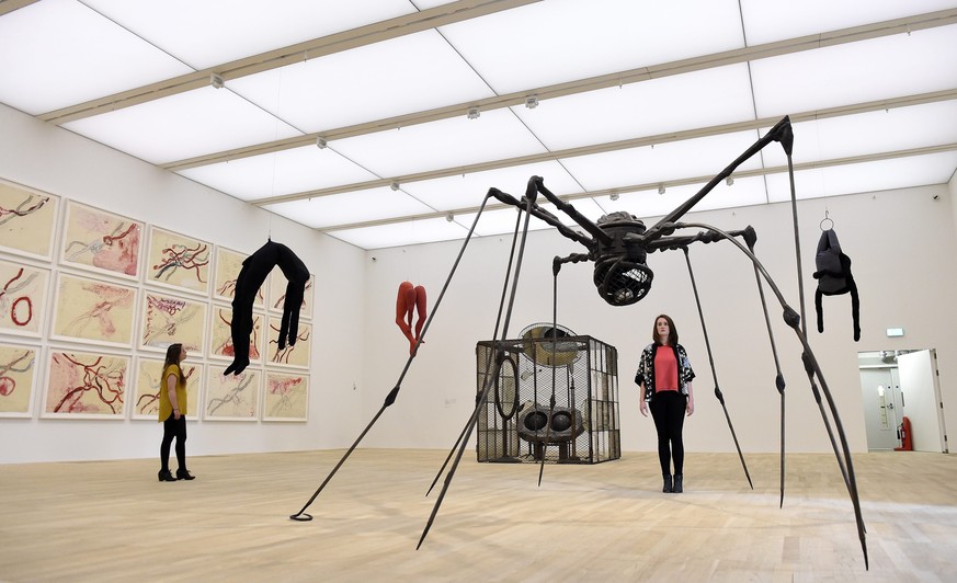 epa05363866 A Tate Modern gallery employee poses for photographs next to works by French-American artist Louise Bourgeois in one of the new artist rooms in the new Switch House building extension to t ...