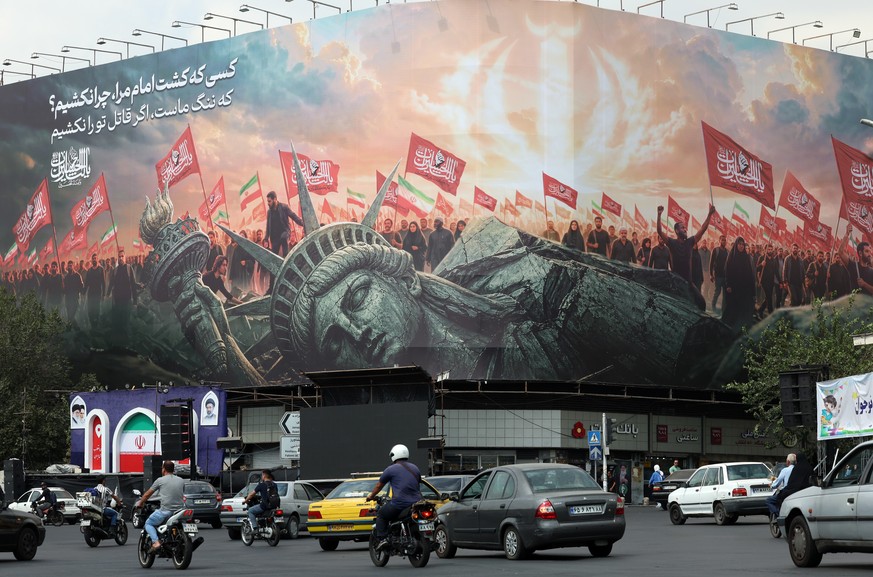 epa13224596 Iranians drive past an anti-US billboard in Tehran, Iran, 09 September 2026. Irans Islamic Revolutionary Guard Corps (IRGC) claims to have captured a US military underwater drone at the e ...