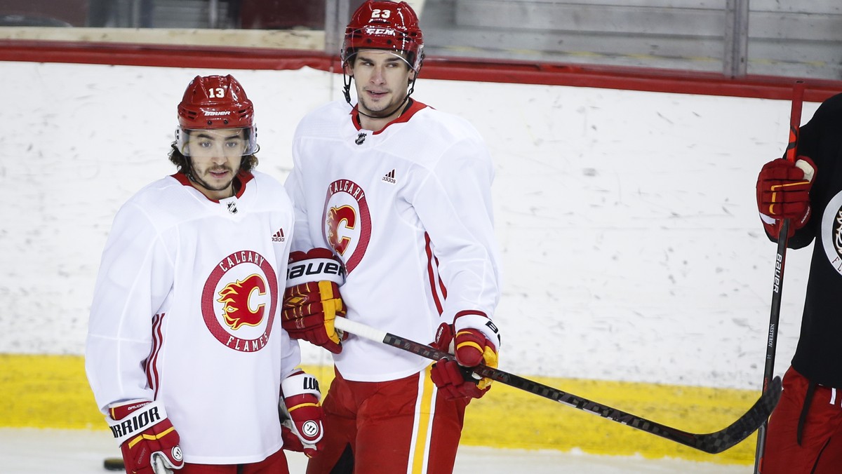 Calgary Flames' Johnny Gaudreau, left, and Sean Monahan look on during a training camp practice in Calgary, Sunday, Jan. 10, 2021. (Jeff McIntosh/The Canadian Press via AP)