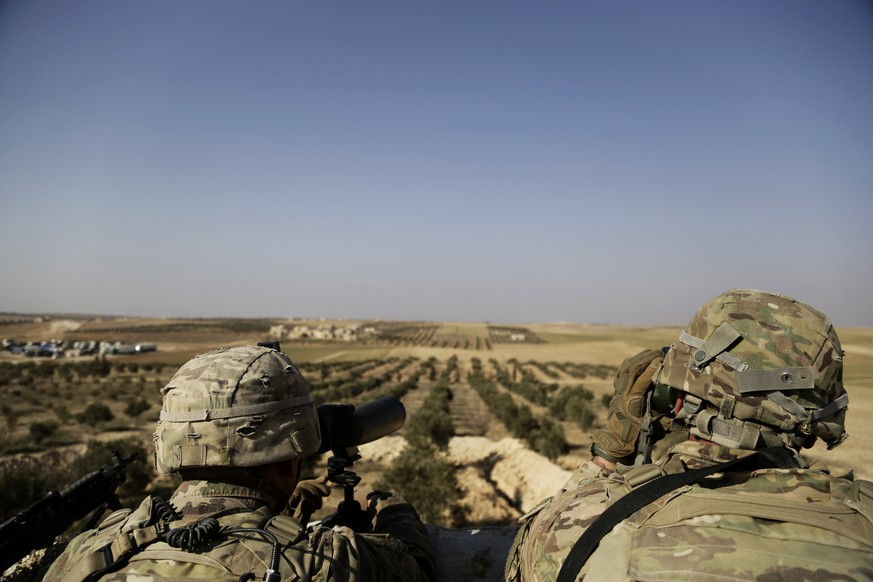 American troops look out toward the border with Turkey from a small outpost near the town of Manbij, northern Syria, Wednesday, Feb. 7, 2018. Lt. Gen. Paul E. Funk, the top U.S. general in the coaliti ...